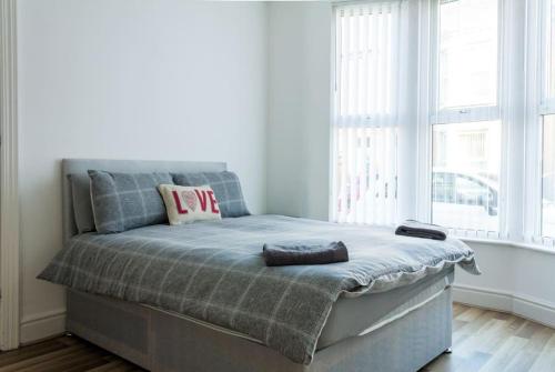 Modern 4 Bed House Sleep 7 في ليفربول: سرير في غرفة مع نافذة كبيرة