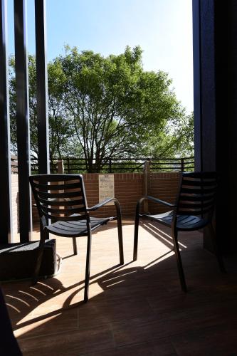 two chairs sitting on a porch with a tree at Lütel Hotel Xpark Gloria Outlets Shin Kong Cinemas in Dayuan