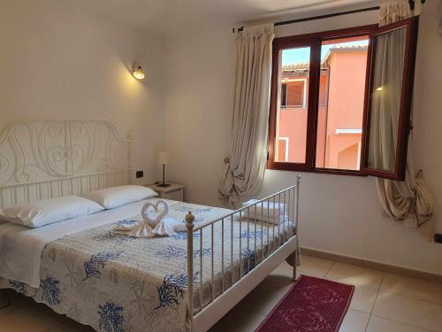 een slaapkamer met een bed en een raam bij Bilocale n 10 Arbatax vicino al mare in Àrbatax