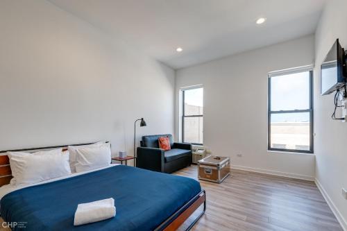 a bedroom with a king sized bed and a chair at River West, Second Floor Chicago by 747 Lofts in Chicago