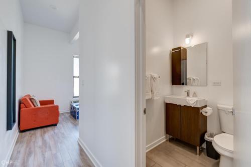 a bathroom with a sink and a toilet and a chair at 747 Lofts by RedAwning - River West, Second Floor Chicago in Chicago