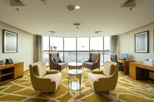 a waiting room with chairs and a table and windows at Wonder Palace Hotel Qatar in Doha