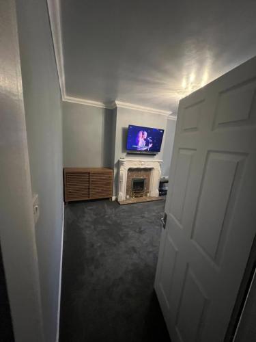 sala de estar con TV y chimenea en Mordern home, en Kippax