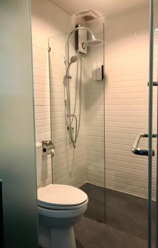a bathroom with a toilet and a glass shower at Tang House in Bangkok