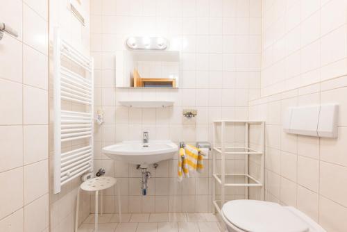 La salle de bains blanche est pourvue d'un lavabo et de toilettes. dans l'établissement Ferienwohnung Scheibe, à Neustift im Stubaital