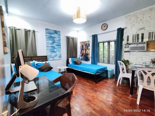 ein Wohnzimmer mit einem blauen Sofa und einem Tisch in der Unterkunft JOIZ HOMESTAY in San Pedro
