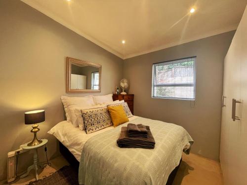 a bedroom with a bed and a mirror on the wall at Alon Cottage in Johannesburg