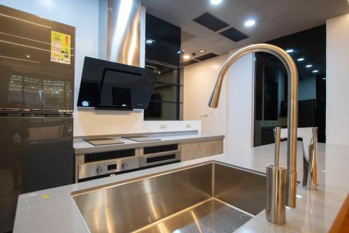a kitchen with a stainless steel sink and a tv at Kenting Fu-Jing Villa in Hengchun