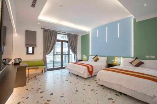 Habitación de hotel con 2 camas, escritorio y habitación en Kenting Fu-Jing Villa, en Hengchun