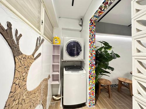 a washer and dryer in a laundry room with a tree mural at Kenting Fu-Jing Villa in Hengchun