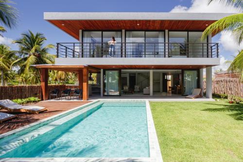 a house with a swimming pool in front of a house at Casa Maçunim 1 in Pôrto de Pedras