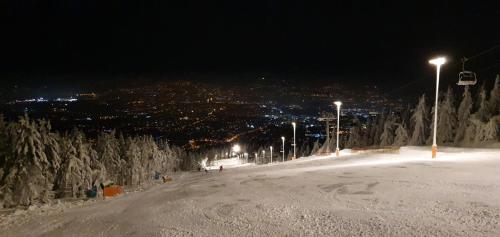 a snow covered ski slope at night with lights at KostelApartmány in Liberec