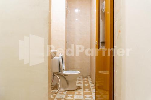 a bathroom with a toilet in a room at Adam Malik Guesthouse near Regale ICC Medan Mitra RedDoorz in Medan