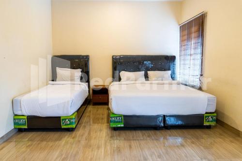 棉蘭的住宿－Adam Malik Guesthouse near Regale ICC Medan Mitra RedDoorz，客房内的两张床,内有盒子