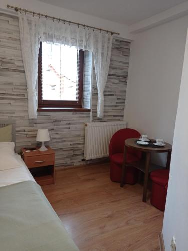ein Schlafzimmer mit einem Bett, einem Tisch und einem Fenster in der Unterkunft Willa Velde in Karpacz