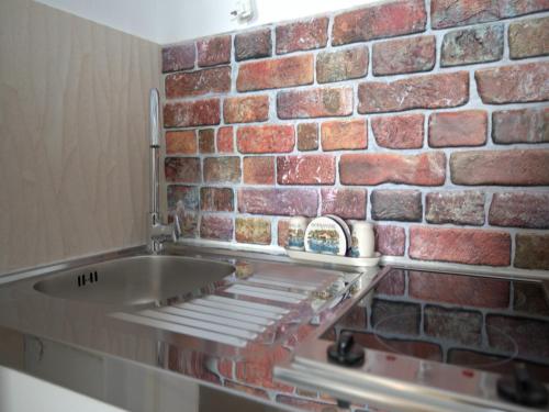 a brick wall in a kitchen with a sink at Apartment Lea in Dubrovnik