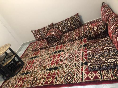 ein Bett mit einem Haufen Decken und Kissen darauf in der Unterkunft السعاده للشقق المفروشة in Medina