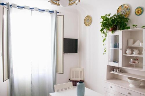 d'une salle à manger avec des murs blancs et une fenêtre. dans l'établissement DAI MORI, à Palerme