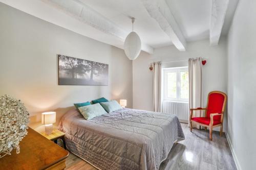 a bedroom with a bed and a red chair at Villa de 4 chambres avec piscine privee jardin amenage et wifi a Saint Sylvestre sur Lot in Saint-Sylvestre-sur-Lot