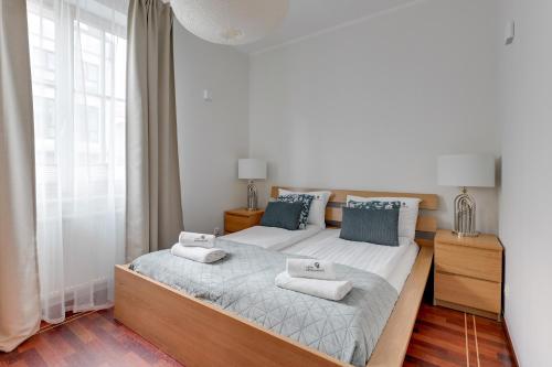 um quarto com uma cama grande com duas toalhas em Lion Apartments - Portofino Familly Apartment at the city center with parking em Sopot