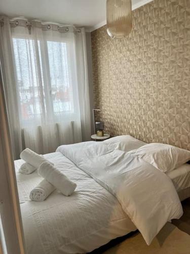uma cama branca num quarto com uma janela em Appartement situé au centre ville d’alfortville em Alfortville