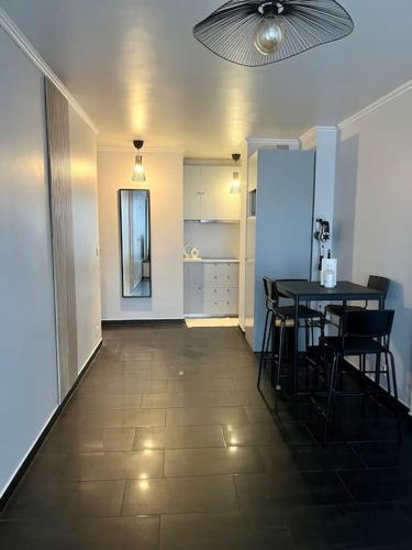 - un couloir avec une table et des chaises dans la chambre dans l'établissement Appartement situé au centre ville d’alfortville, à Alfortville