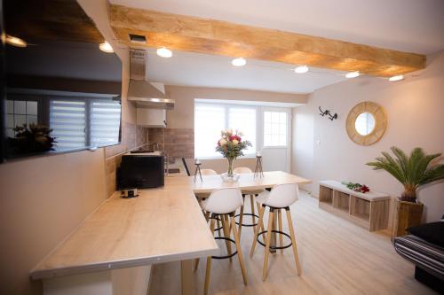 a kitchen with a table and stools in a room at ODYSSEE l'expérience commence ici JACUZZI in Saint-Jean-Bonnefonds