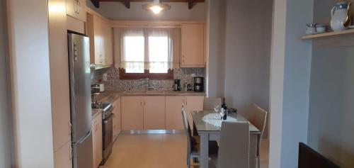 eine Küche mit einem Tisch und eine Küche mit einem Fenster in der Unterkunft Armiriki Apartments in Korakokhórion
