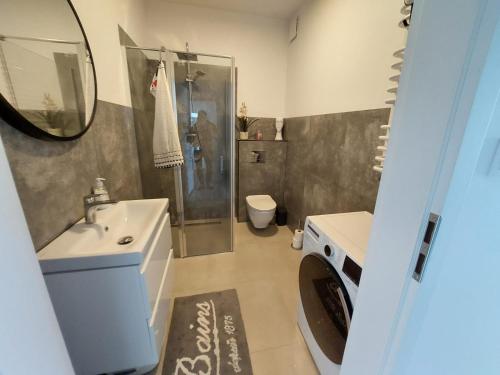 ein Badezimmer mit einem Waschbecken, einem WC und einem Spiegel in der Unterkunft Apart Białe Augustów in Augustów