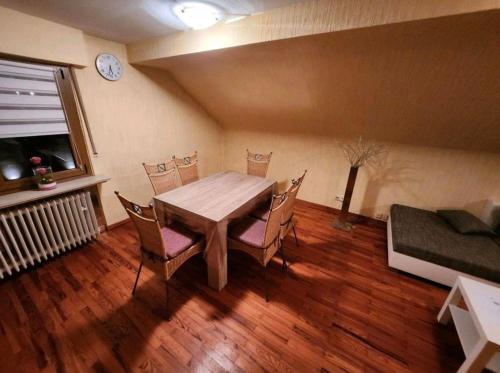 comedor con mesa de madera y sillas en Ferienwohnung-Michelle en Waldrach