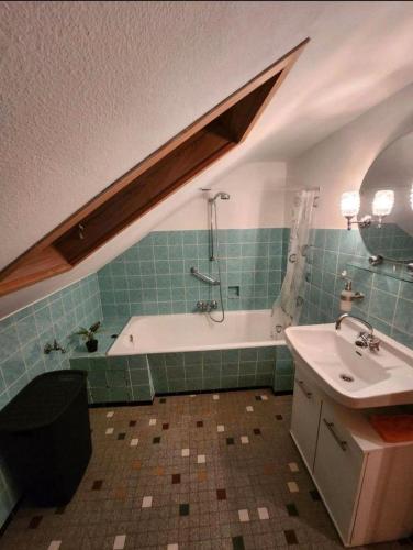 a bathroom with a bath tub and a sink at Ferienwohnung-Michelle in Waldrach