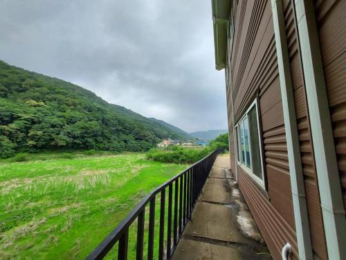 a balcony of a house with a view of a field at 미리내 호숫가 독채펜션 in Anseong