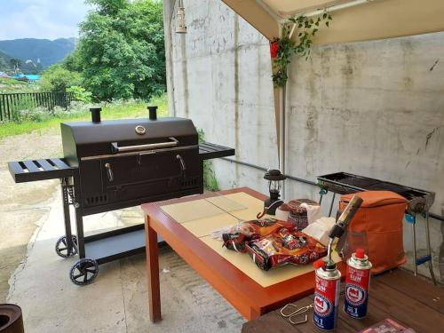 a grill and a table with a table sidx sidx at Lakeside Mirinae Villa in Anseong