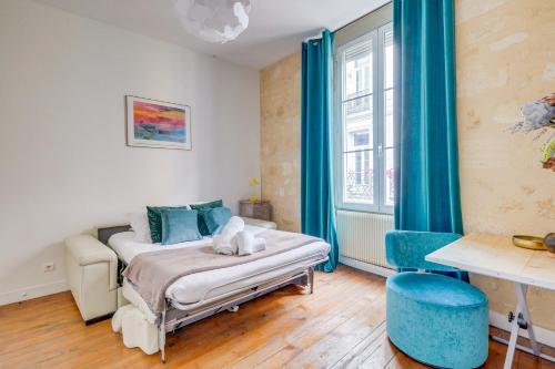 une chambre avec un lit et une fenêtre avec des rideaux bleus dans l'établissement Chez Jeanne - Appartement Hyper Centre, à Bordeaux