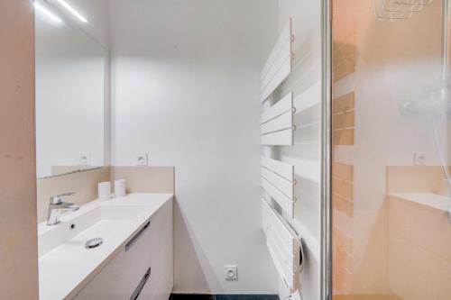 une salle de bain avec un lavabo et un miroir dans l'établissement Chez Jeanne - Appartement Hyper Centre, à Bordeaux