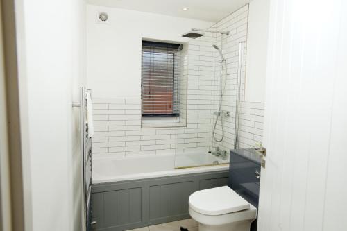 a bathroom with a toilet and a bath tub at Number 4 on The Hill in Lincolnshire