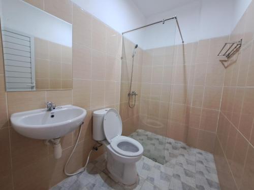 a bathroom with a toilet and a sink at Pillow Guest House in Balikpapan