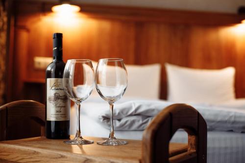 una bottiglia di vino e due bicchieri di vino su un tavolo di Private Rooms in Hotel Lift 1R a Bukovel