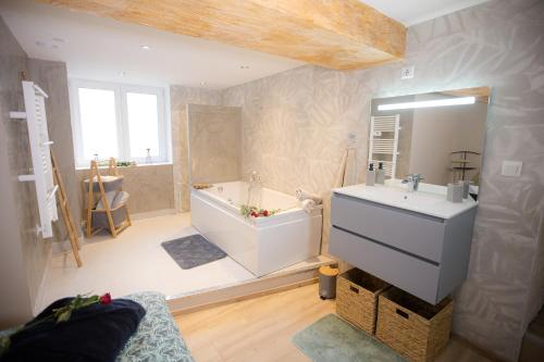 a large bathroom with a tub and a sink at ODYSSEE l'expérience commence ici JACUZZI in Saint-Jean-Bonnefonds