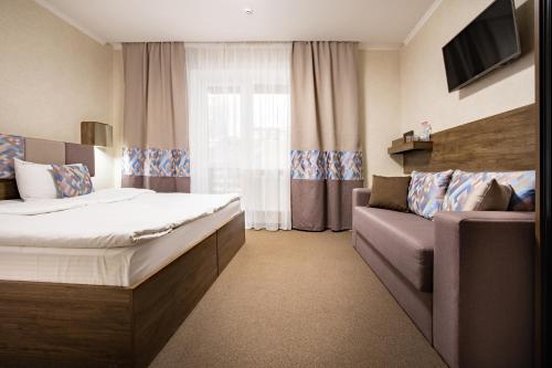 a hotel room with a bed and a couch at Private Rooms in Hotel 3 поверх in Bukovel