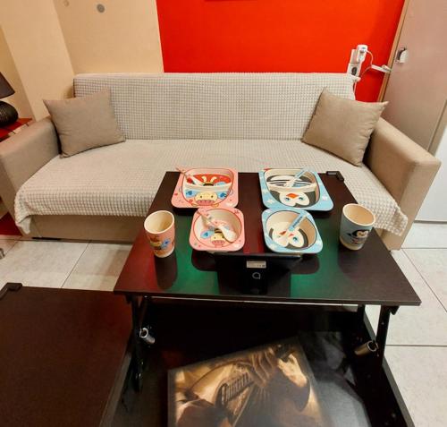 a living room with a couch and a table with dishes on it at Apollo 2 - Luxury Apartment in Katerini