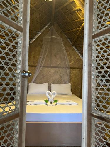 a bed in a yurt with a door open at Kanipa Beach Glamping in El Nido