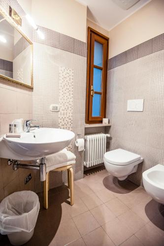 a bathroom with a sink and a toilet at La Grotta Hotel in San Marino