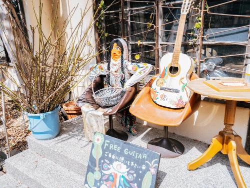 a person sitting in a chair next to a guitar at Hotel AreaOne Takamatsu in Takamatsu