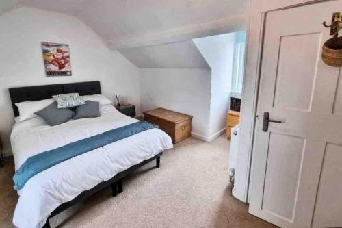 a bedroom with a large bed and a door at Mermaid Cottage Teignmouth by the beach SLEEPS 7 in Teignmouth