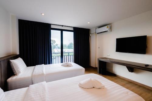 a hotel room with two beds and a flat screen tv at JS HOTEL in Hat Yai
