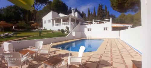 a white house with a swimming pool and chairs at casanicky in Mijas