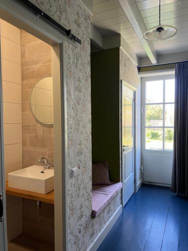 baño con lavabo, bañera y ventana en Bertha's Hofstede, 