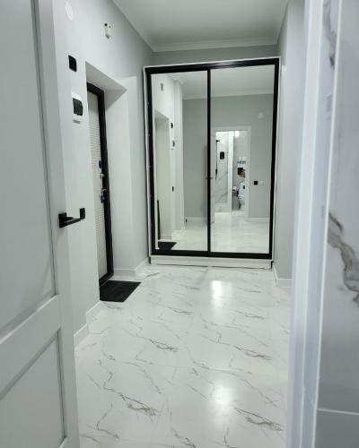 a hallway with a mirror and a door and a room at К7 family in Atyraū