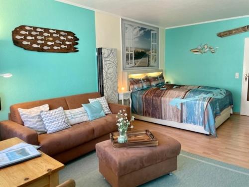 uma sala de estar com um sofá e uma cama em 13-18, sehr Strandnah, im Herzen Westerlands, Westbalkon, 1 Zi em Westerland